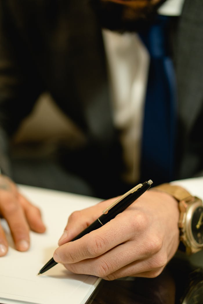 Close-up of hand signing a legal contract with a pen. Ideal for business and legal themes.